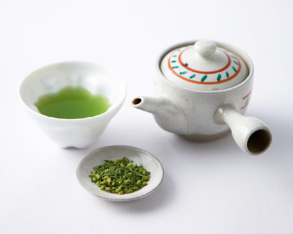 画像：玄米茶の入った急須とお湯呑みと茶葉