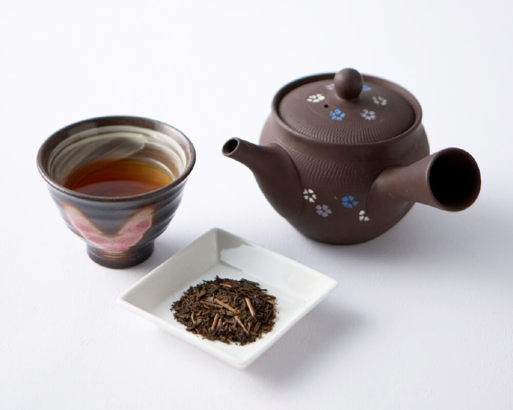 画像：上ほうじ茶の入った急須とお湯呑みと茶葉